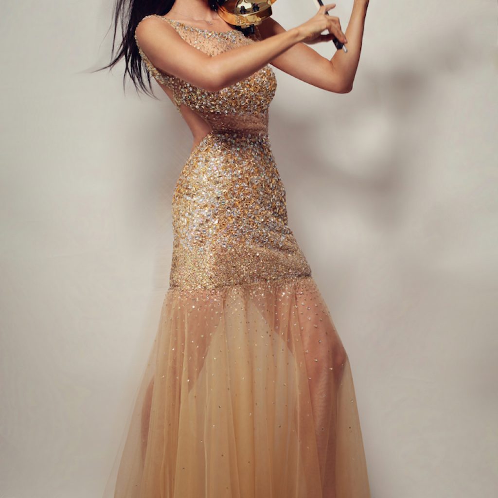 Violinist Linzi Stoppard performing on golden violin wearing shimmering gold dress